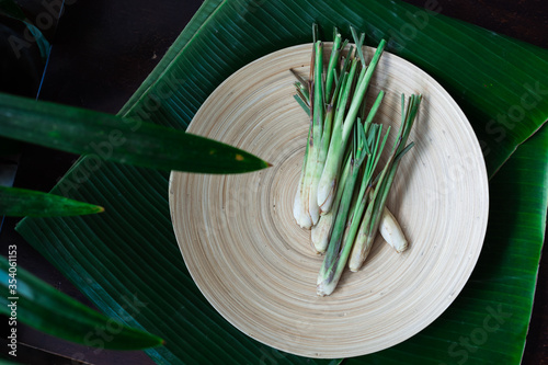 Fresh Lemongrass (Cymbopogon citratus) or citronella, serai on a wooden plate.