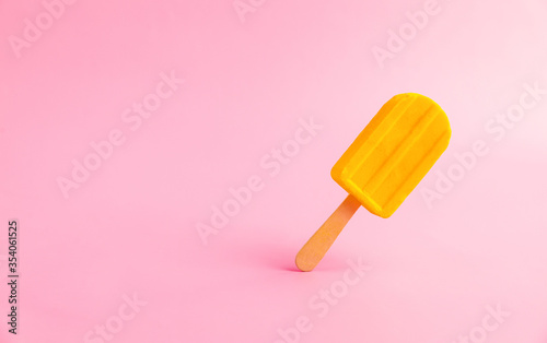 Yellow banana popsicle isolated on pastel pink background with copy space photo