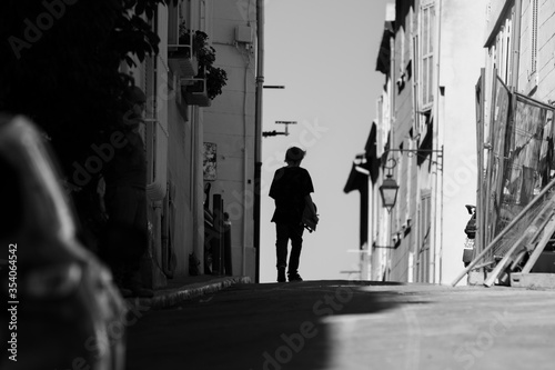 A skateboarder walking in the street © Maxime