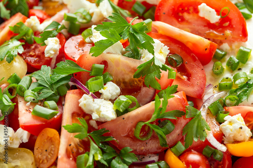 Tomato salad with feta cheese, spring onion and parsley. Healthy summer food