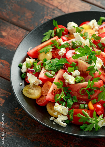 Tomato salad with feta cheese, spring onion and parsley. Healthy summer food