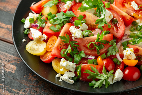 Tomato salad with feta cheese, spring onion and parsley. Healthy summer food