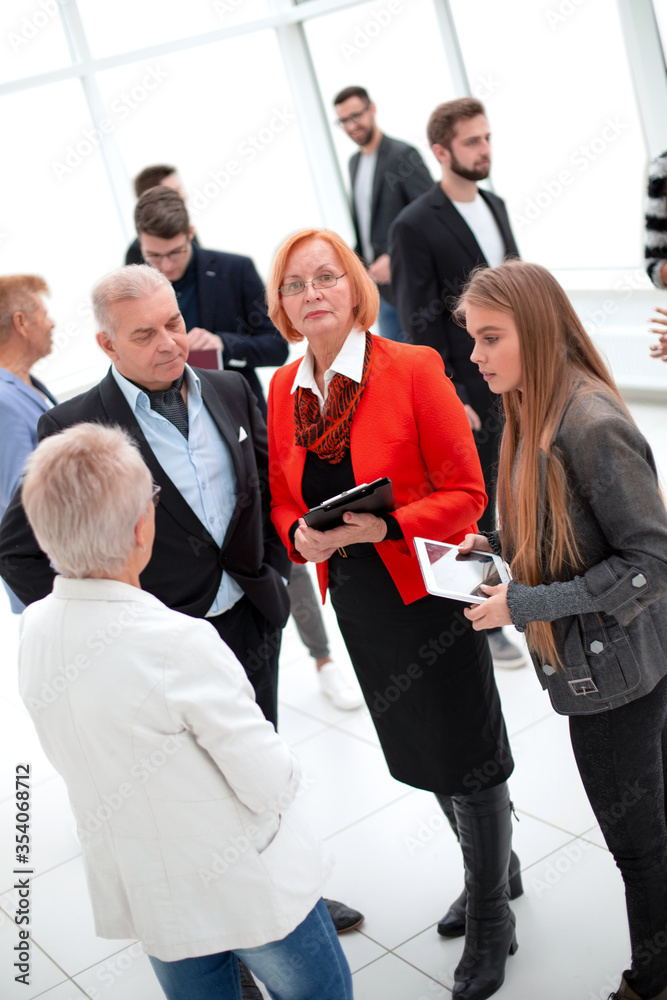 Group of businesspeople standing inside an office with digital tablet Group of businesspeople standing inside an office with digital tablet