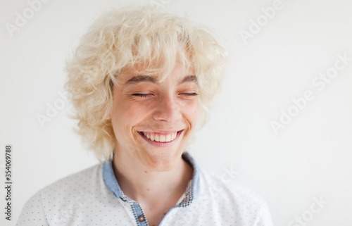 Portrait of cheerful young blond man smiling looking at camera