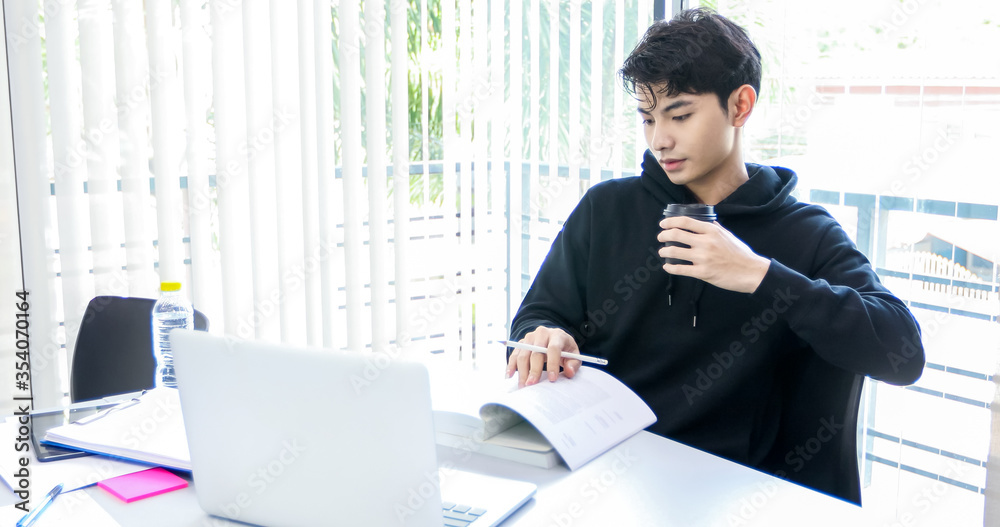 Asian man students read books and use computer notebook to find information for work and online studies. Asian man students read books and use computer notebook to find information for work and online studies.