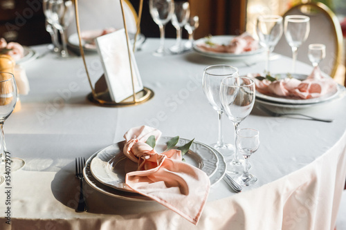 Close up festive table setting with empty wine glasses and white plate