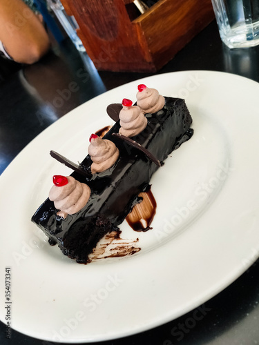 Chocolate mousse with whipped cream and cherries on top.