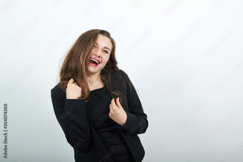 Young Attractive Woman Brunette In In A Black T-Shirt And Sweater On White Background, Happy Female Smiling, Raised Her Hands. The Concept Is Bliss People Young Attractive Woman Brunette In In A Black T-Shirt And Sweater On White Background, Happy Female Smiling, Raised Her Hands. The Concept Is Bliss People
