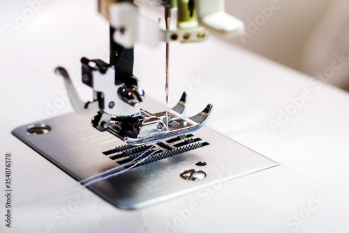 Sewing machine. Handmade work. Textile factory. Sewing machine sews fabric.