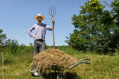 Agriculteur en colère avec fourche et brouette photo