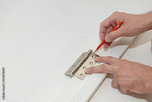 Installing the door hinge on a white door leaf