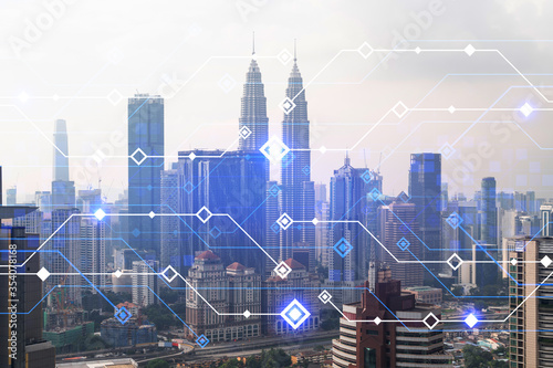 Technology hologram over panorama city view of Kuala Lumpur. KL is the largest tech hub in Malaysia, Asia. The concept of developing coding and high-tech science. Double exposure.