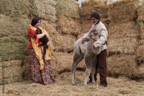 Young farmer man and woman with Camel and lamb at the farm