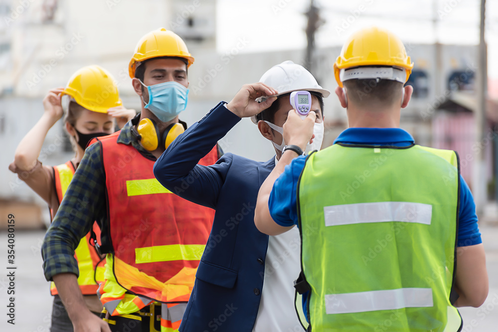 Workers with protective mask, Engineer worker waring surgical mask checking body temperature using infrared digital thermometer check temperature before into work place, Workers with protective mask, Engineer worker waring surgical mask checking body temperature using infrared digital thermometer check temperature before into work place,