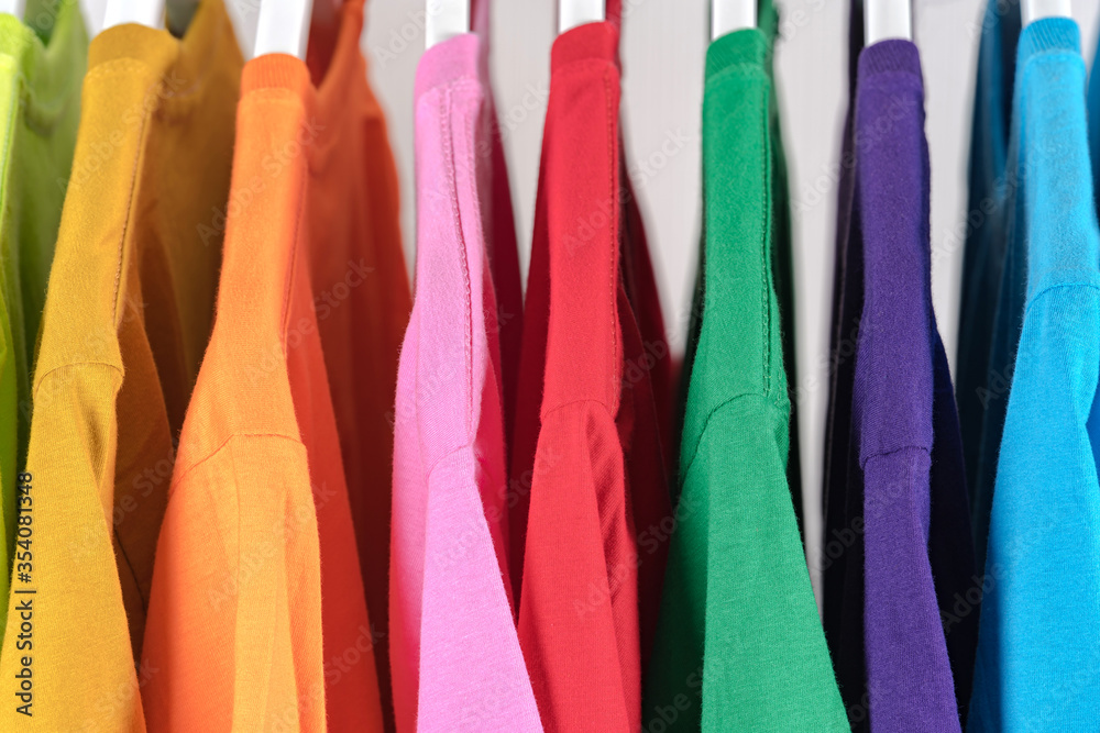 Close Up of t-shirts, Clothes on hangers on white background Close Up of t-shirts, Clothes on hangers on white background