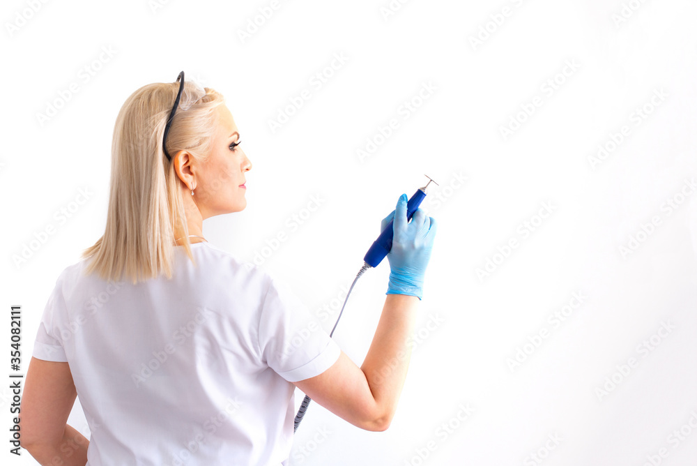 The doctor with the device in his hands. medical instrument. virus treatment. coronovirus. COVID. disk for hardware pedicure in the master's hands. isolate, copy space. Beauty Industry Concept. The doctor with the device in his hands. medical instrument. virus treatment. coronovirus. COVID. disk for hardware pedicure in the master's hands. isolate, copy space. Beauty Industry Concept.