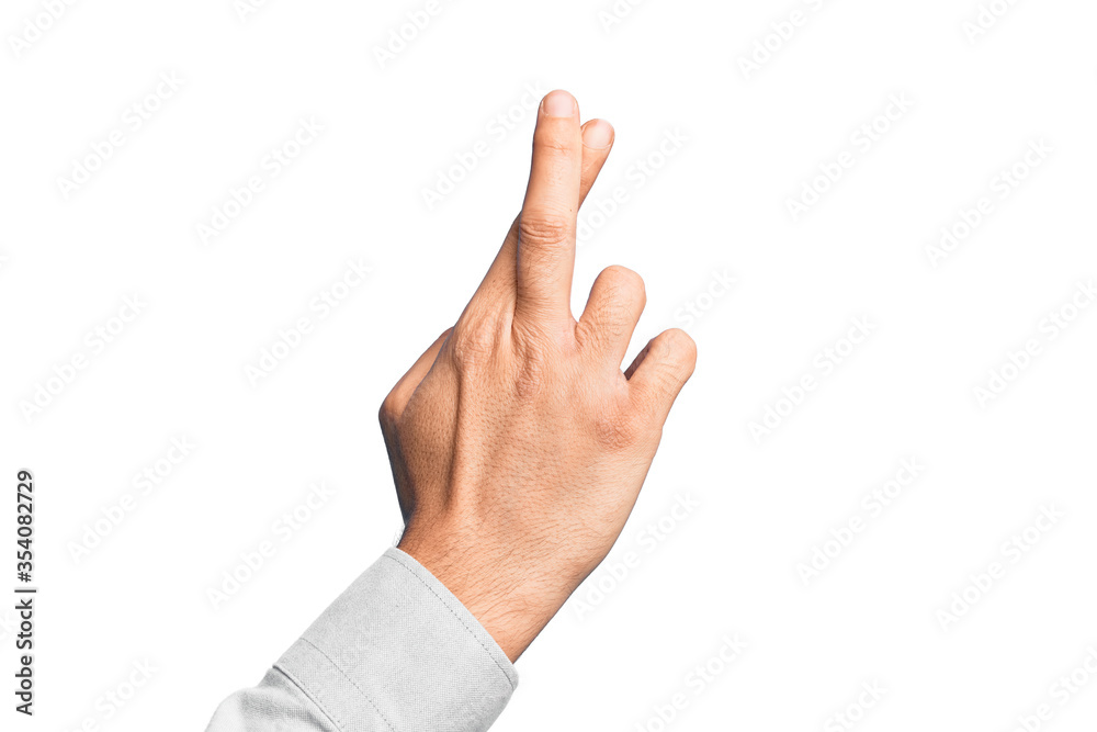 Hand of caucasian young man showing fingers over isolated white background gesturing fingers crossed, superstition and lucky gesture, lucky and hope expression Hand of caucasian young man showing fingers over isolated white background gesturing fingers crossed, superstition and lucky gesture, lucky and hope expression