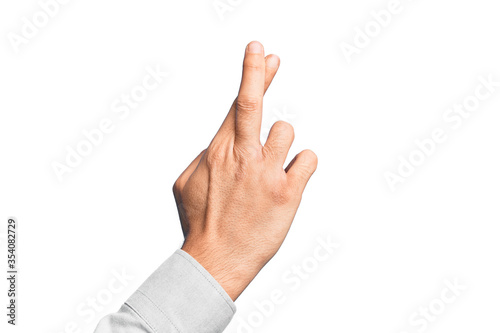 Hand of caucasian young man showing fingers over isolated white background gesturing fingers crossed, superstition and lucky gesture, lucky and hope expression