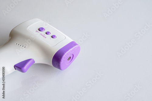 closeup infrared thermometer in white table background. top view. spact for text