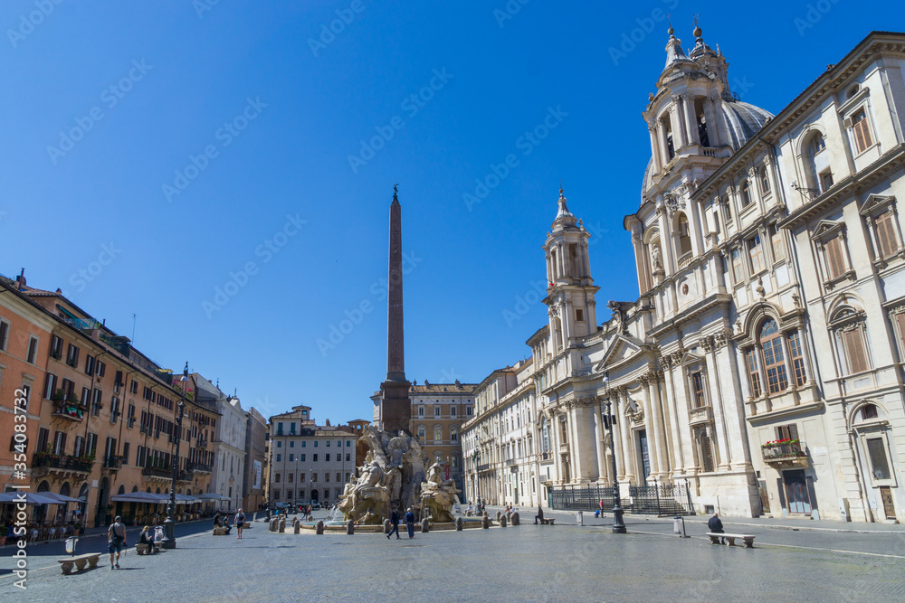 Fototapeta premium Fountain of the Four Rivers with an Egyptian obelisk and Sant Agnese Church on the famous Piazza Navona Square in the morning, Rome, Italy
