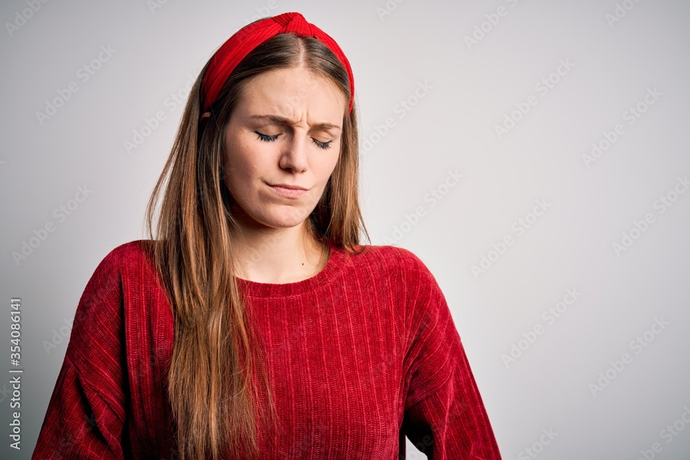 Young beautiful redhead woman wearing red casual sweater and diadem over yellow background with hand on stomach because indigestion, painful illness feeling unwell. Ache concept. Young beautiful redhead woman wearing red casual sweater and diadem over yellow background with hand on stomach because indigestion, painful illness feeling unwell. Ache concept.