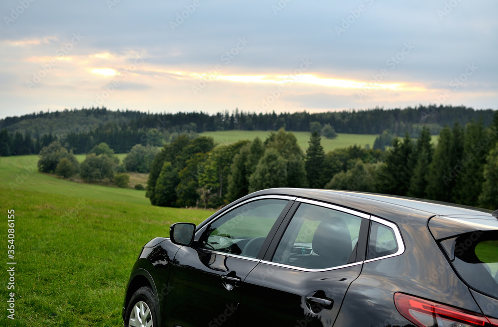 Fototapeta premium Modern black SUV crossover car vehicle in nature at sunrise.