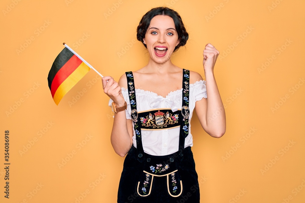 Young patriotic german woman with blue eyes wearing octoberfest dress holding germany flag screaming proud and celebrating victory and success very excited, cheering emotion Young patriotic german woman with blue eyes wearing octoberfest dress holding germany flag screaming proud and celebrating victory and success very excited, cheering emotion