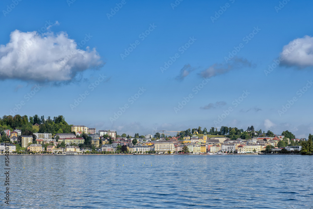 View over blue water of Lake Traunsee to Gmunden under blue sommer sky with white clouds, Salzkammergut, Upper Austria, Europe