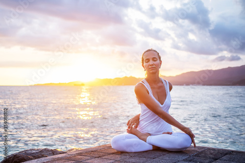 Woman practices yoga at seashore