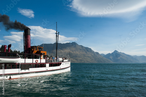 Steamship departing pier at Queenstown, New Zealand into Lake Wakatipu with the Remarkables in background