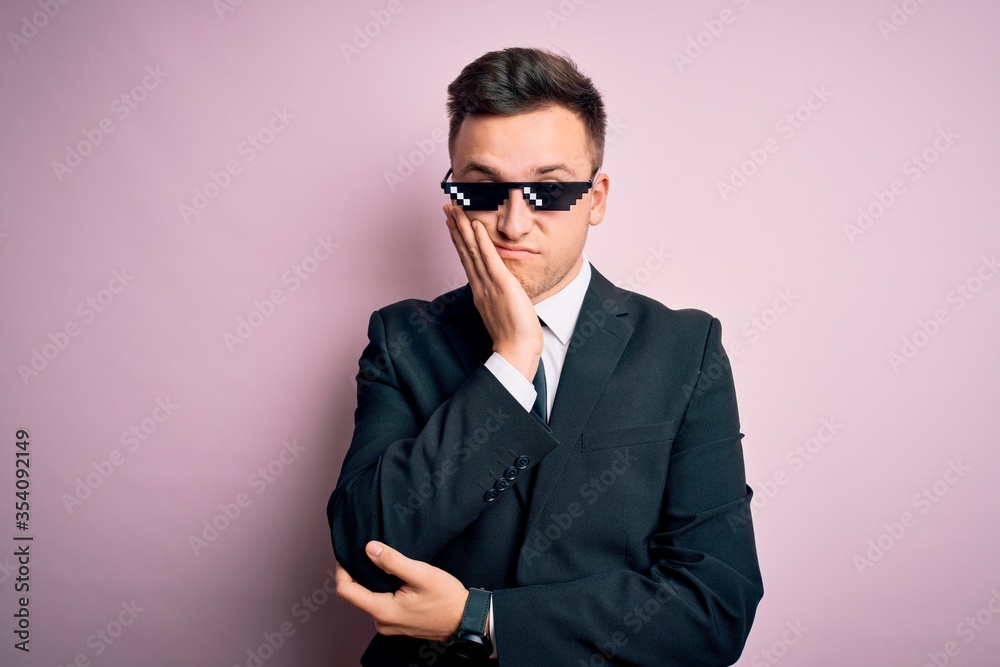 Young handsome caucasian business man wearing funny thug life glasses thinking looking tired and bored with depression problems with crossed arms. Young handsome caucasian business man wearing funny thug life glasses thinking looking tired and bored with depression problems with crossed arms.