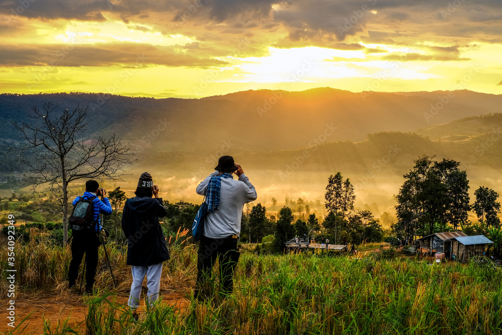 December,2019 : Backside of tourists taking photo the sunrise at Phu Kho,Loei province,Thailand.