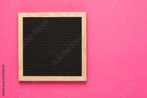 Empty black letterboard on pink background. Design mockup photo