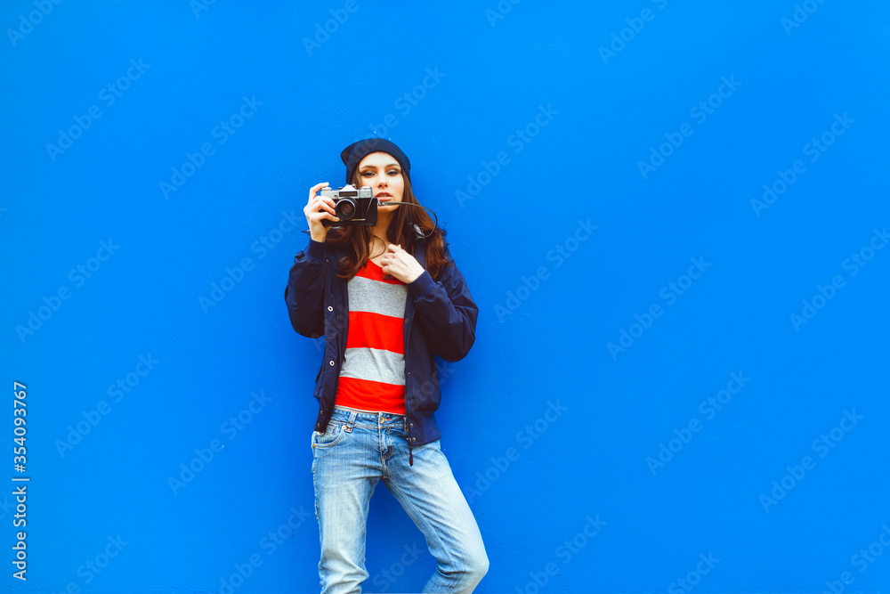 portrait of a beautiful hipster girl with a camera on the background photon makes the blue wall portrait of a beautiful hipster girl with a camera on the background photon makes the blue wall