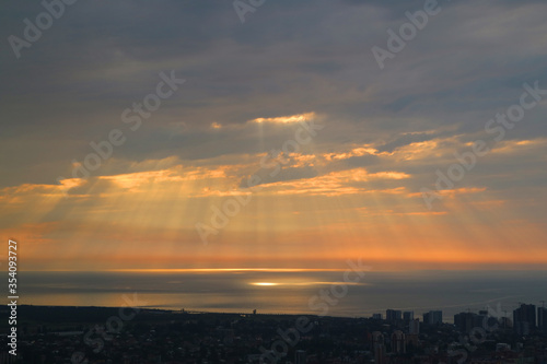 Breathtaking Sunrise Sky with the God Ray over the Sea and the City