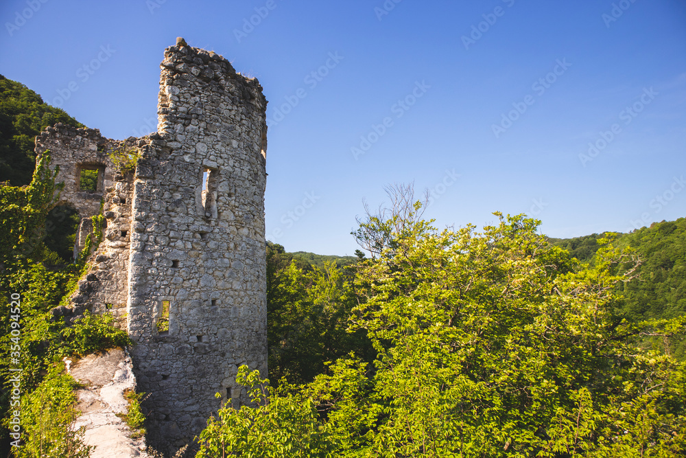 Forsaken, old, stone castle ruins on Tepec hill, overlooking town of Samobor beneath, standing above dense forest surrounding nearby hills