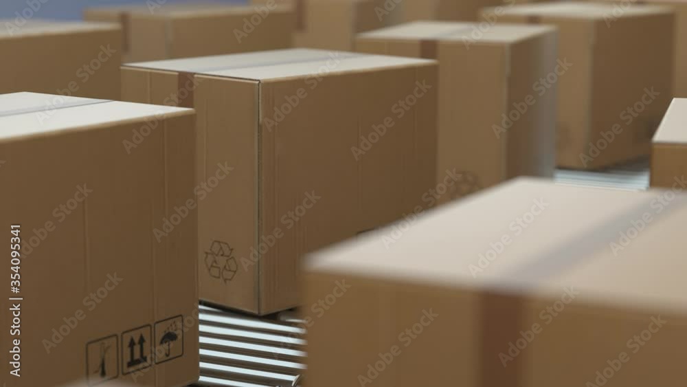 4K Loop Cardboard boxes on conveyor belt line isolated on white grey background. Distribution warehouse. E-commerce, storage, delivery and packaging service concept. Close up, DOF. 3d animation