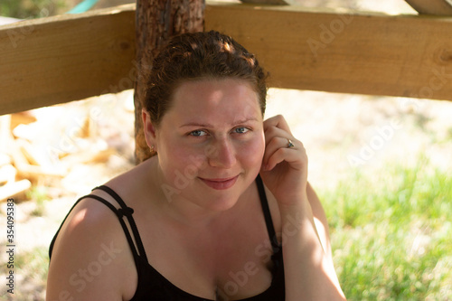 
Portrait of a plus size tanned girl, she smiles and looks at the camera.