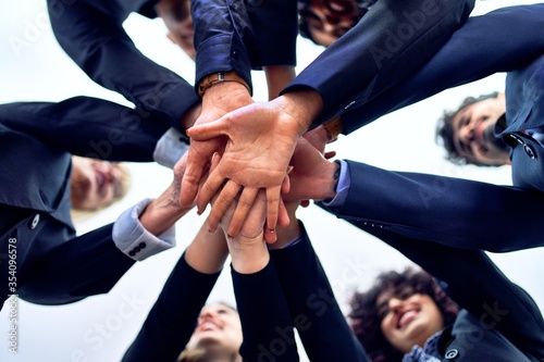 Group of business workers standing with hands together at the office