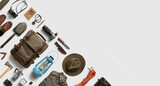 Top view of hiking and camping items arranged on abstract white background with empty space