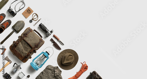 Leinwand Poster Top view of hiking and camping items arranged on abstract white background with