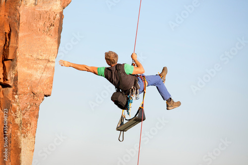 Photography Rock climber and photographer Norbert Frank ascending a rock with a rope