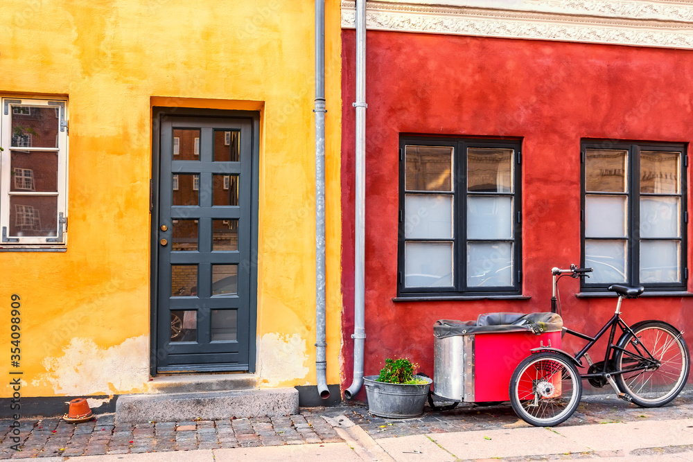 Old red and yellow houses in the center of Copenhagen with typical bicycle. Old Medieval district in Copenhagen, Denmark