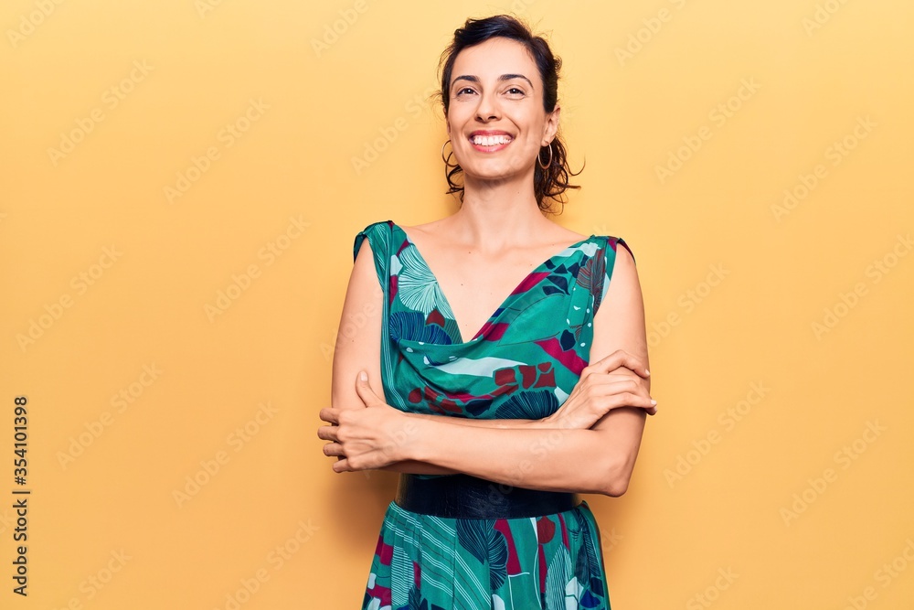Young beautiful hispanic woman wearing casual dress happy face smiling with crossed arms looking at the camera. positive person. Young beautiful hispanic woman wearing casual dress happy face smiling with crossed arms looking at the camera. positive person.