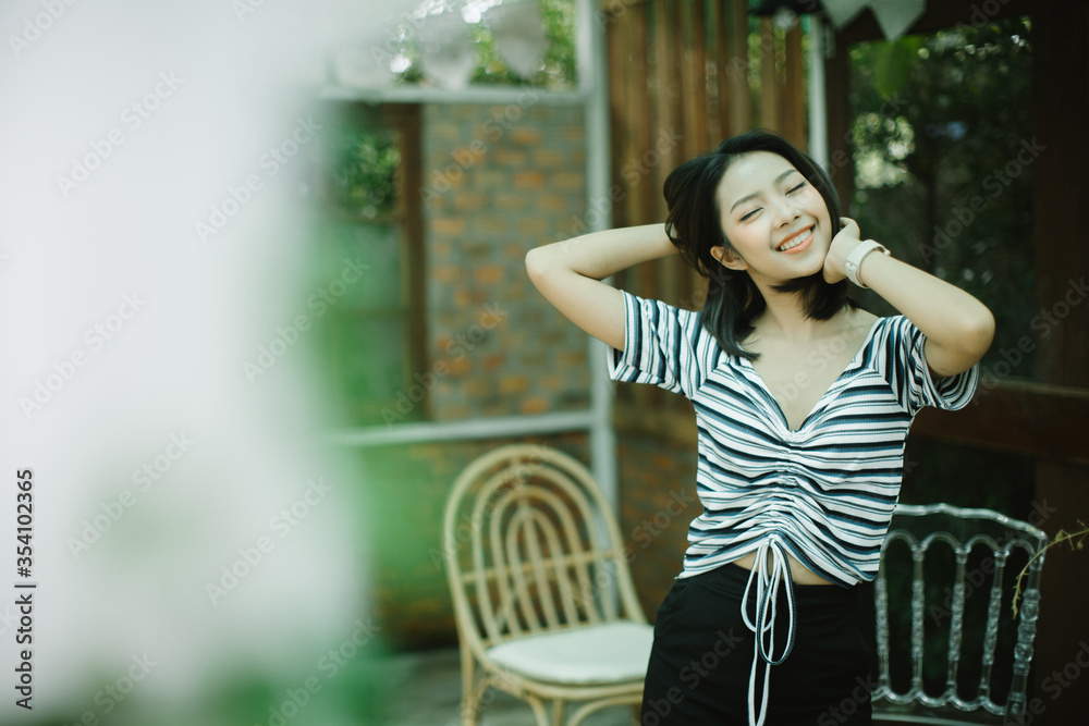 Summer sunny lifestyle fashion portrait of young stylish hipster Asia woman walking on the street, wearing cute trendy outfit