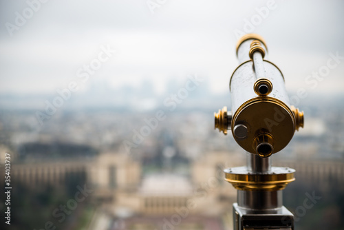 Eiffel Tower telescope overlooking for Paris. Old panoramic viewer or telescope on the Eiffel tower top. Monocular telescope at Eiffel Tower and view over the city.