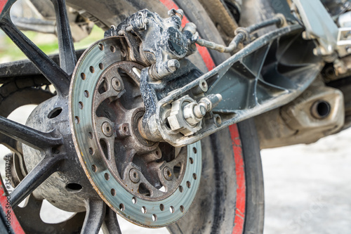 Closeup of motorbike rear wheel. Bike parked near home. Stock photo.