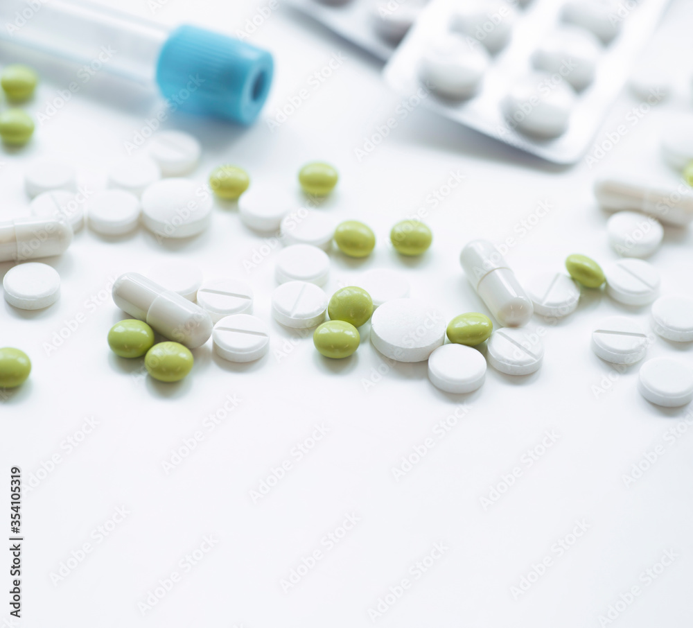 A health examination using a blood test and treatment with pills according to the results of the examination on a white table with an empty place for text A health examination using a blood test and treatment with pills according to the results of the examination on a white table with an empty place for text