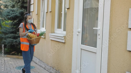 Wallpaper Mural A teenage girl volunteer passes a basket of food to a woman who is under home quarantine. Torontodigital.ca