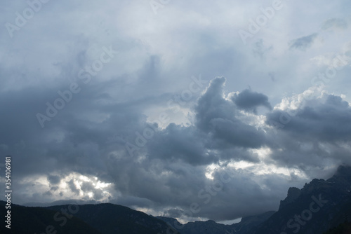 un paesaggio di montagna ricco di nuvole che si colorano in modo particolare con la luce del sole, donando alla situazione un'aspetto quasi fiabesco photo